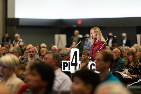 Woman in crowd standing at microphone